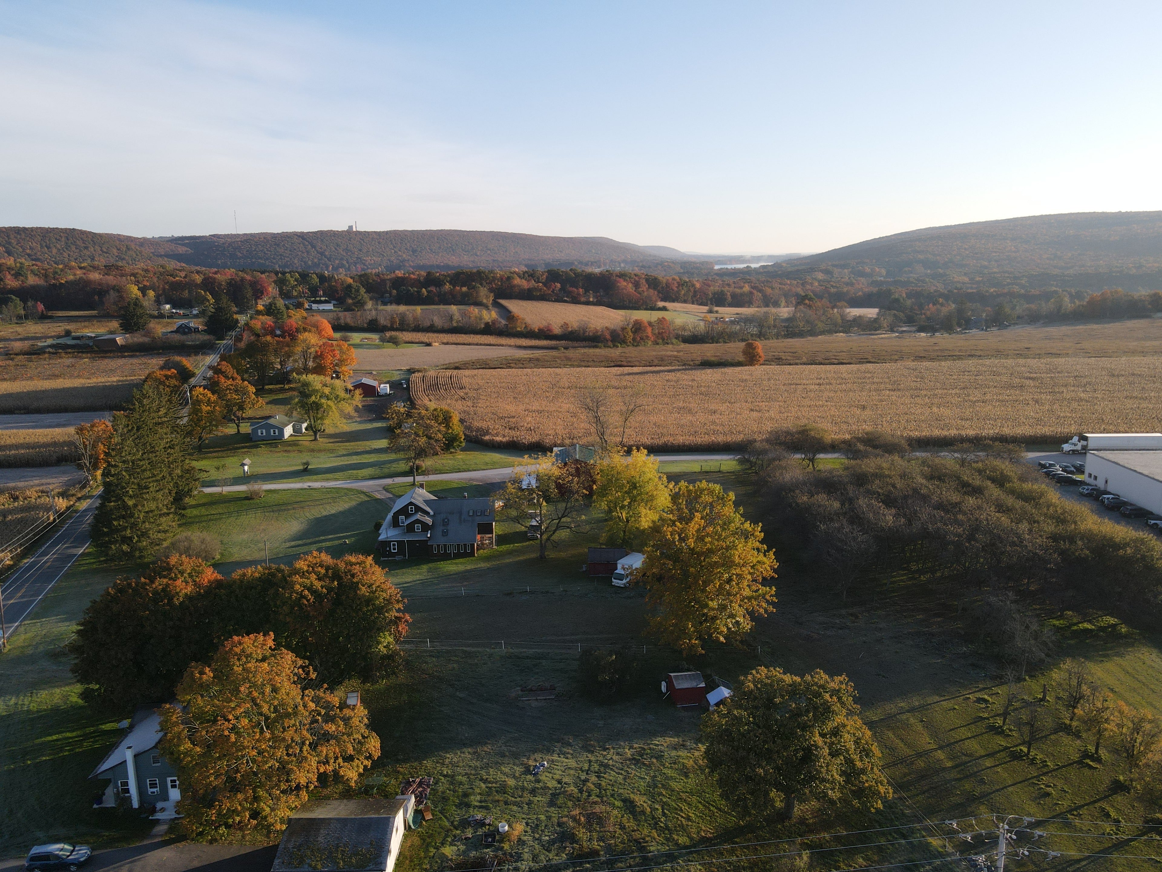 Mountains in background and farmhouse in front with farmland 